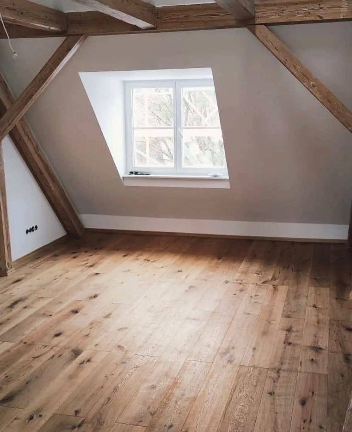 Converted loft with exposed timber beams and oak floorboards